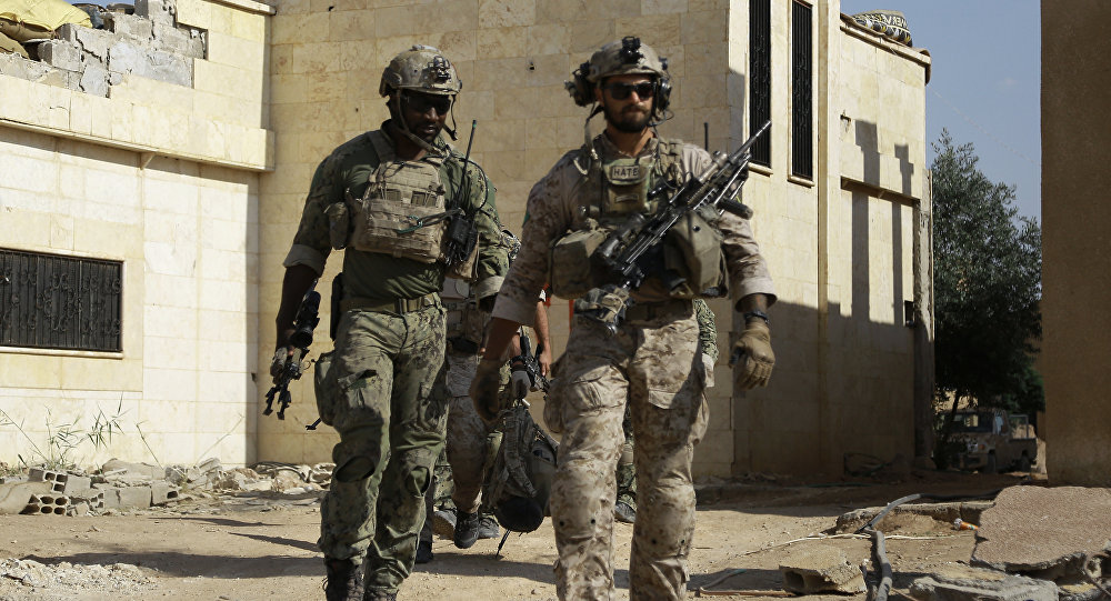 Armed men in uniform identified by Syrian Democratic forces as US special operations forces walk in the village of Fatisah in the northern Syrian province of Raqa on May 25, 2016